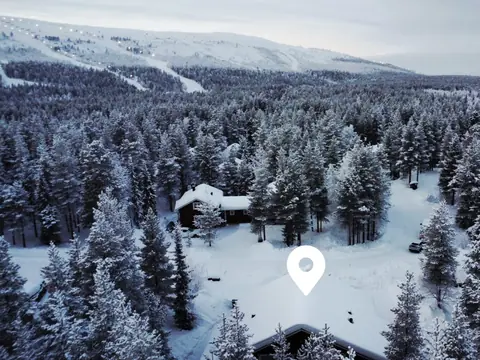 Aerial view of the snowy forest around Chalet Nulkka with the Levi slopes behind