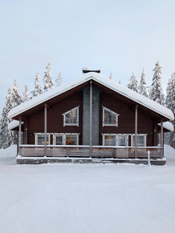 Chalet Nulkka cabin front with snow-covered pines in Levi