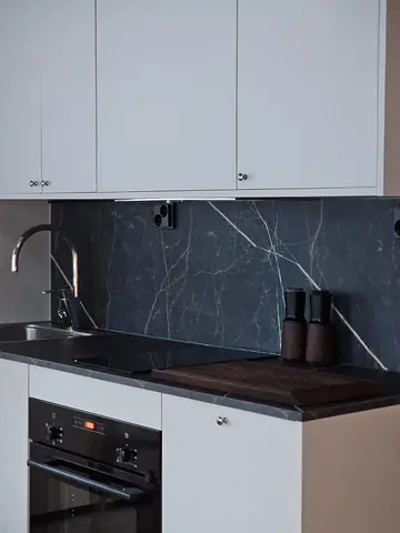 Kitchen with black stone worktop, induction hob and oven