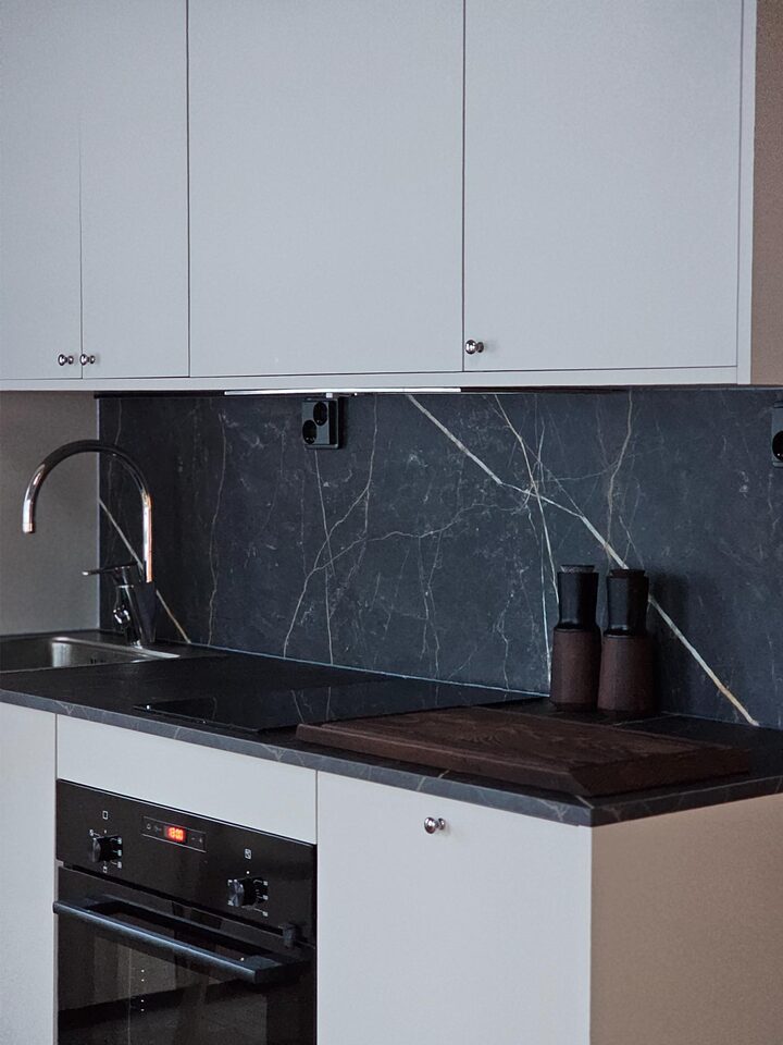 Kitchen with black stone worktop, induction hob and oven