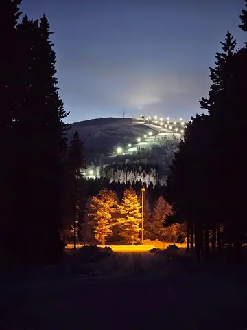 Floodlit Levi ski slope glowing in the evening, seen from near the chalet