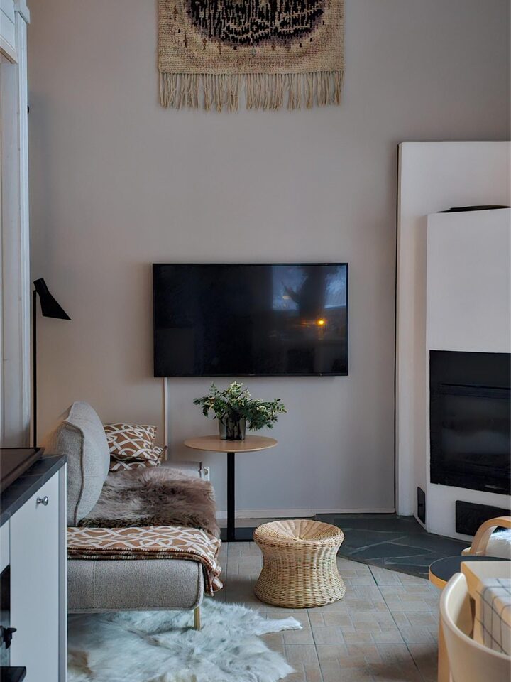 Living room with stone fireplace, TV and Finnish design armchairs at Chalet Nulkka