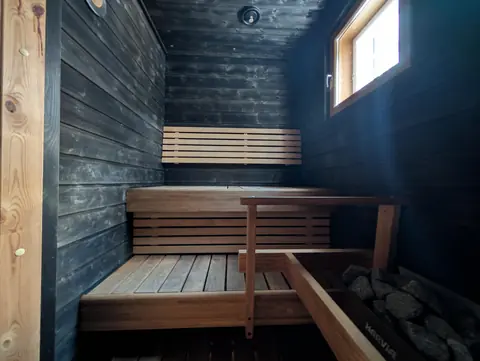 Private Finnish sauna with dark wood panelling and a window
