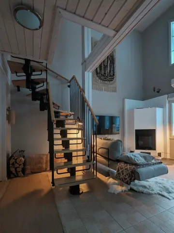 Open staircase to the upper floor beside the living room sofa